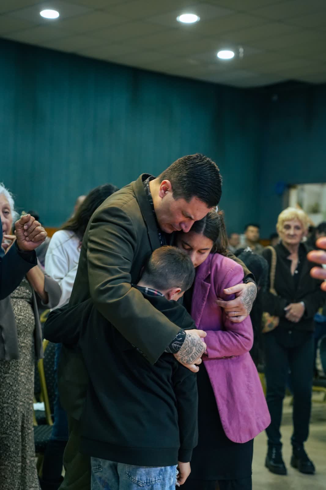 Un pastor orando junto a una familia